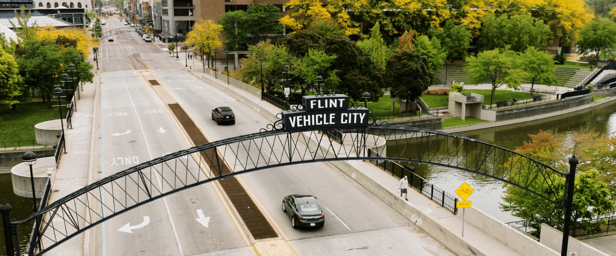 Drone image of cars driving into downtown Flint.