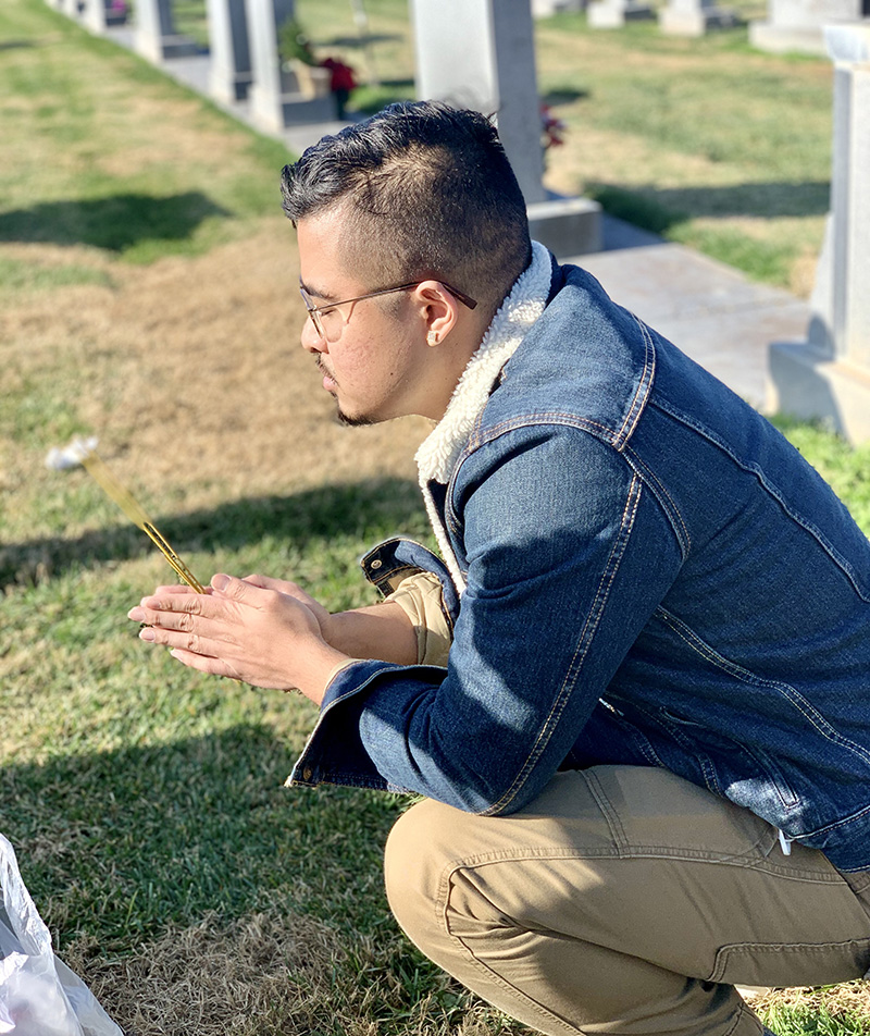 Sunny Panh, MD candidate, praying at family gravesite