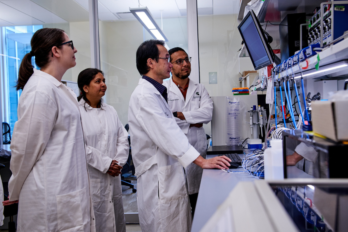 A group of researchers looking at data on a computer.