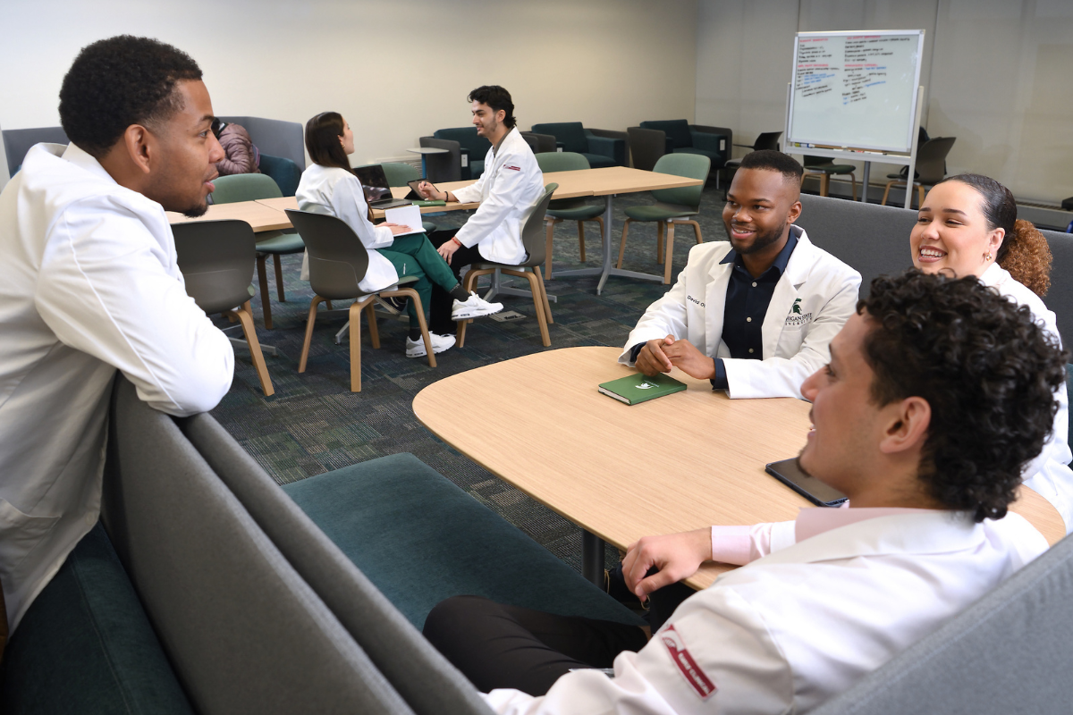 Med student having small group discussions in an open setting.