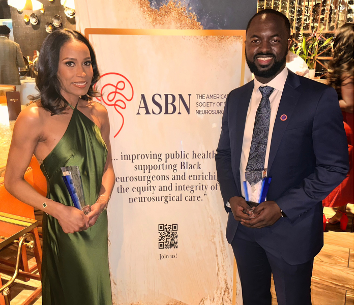 Bah posed in front of the ASBN sign holding the award.