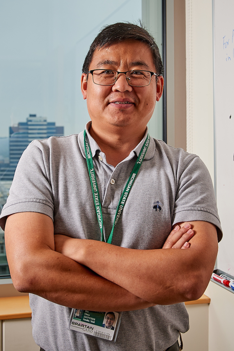 Bin Chen posed in front of a whiteboard.