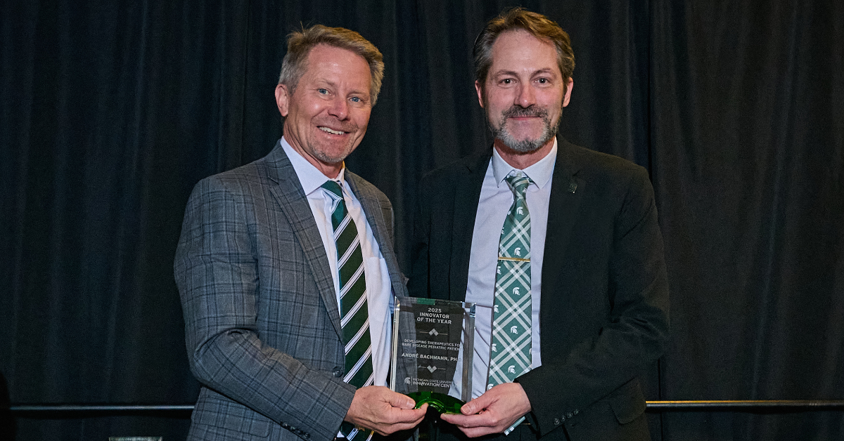 Andre S. Bachmann standing beside MSU President Kevin M. Guskiewicz, in reception of the 2025 MSU Innovator of the Year Award