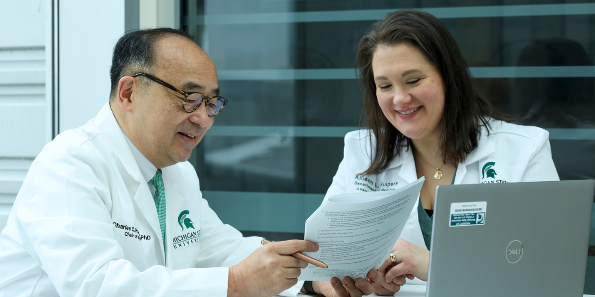 Chaz Hong and Allison Kuipers reviewing research documentation. medicine