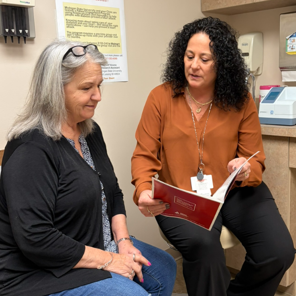 Jane Hiske and Sandy Samp reviewing enrollment documents.