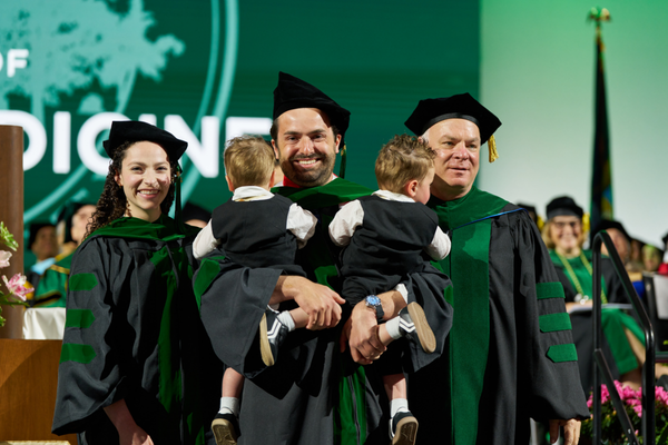 commencement-2026-grad-parent-with-two-children.png