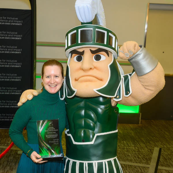 Freidhoff standing with Sparty.