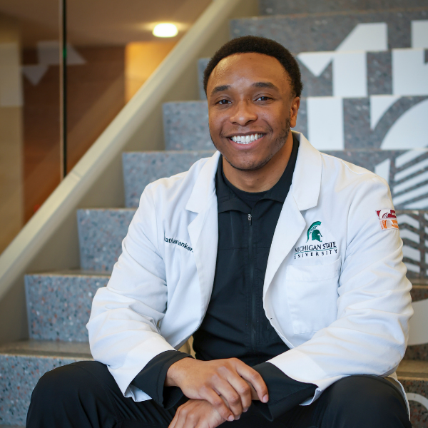 Nathan Hankerson sitting on the stairs in the Secchia Center.