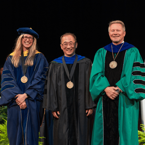 Dohun Pyeon, center, with the provost and president at the 2026 investiture.