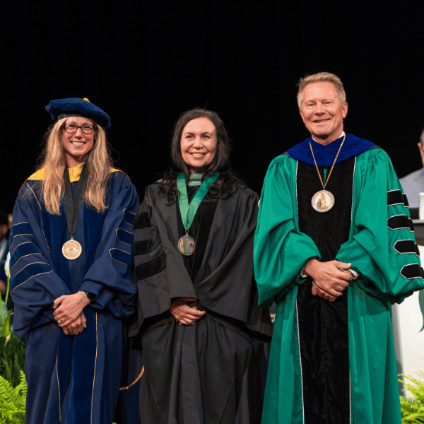 Melissa Bauer, center, with the provost and president at the 2026 investiture.