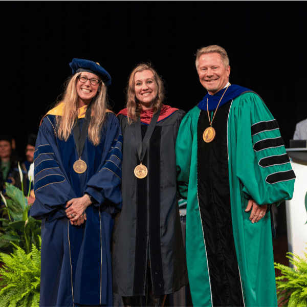 Natoshia Cunningham, center, with the provost and president at the 2026 investiture.