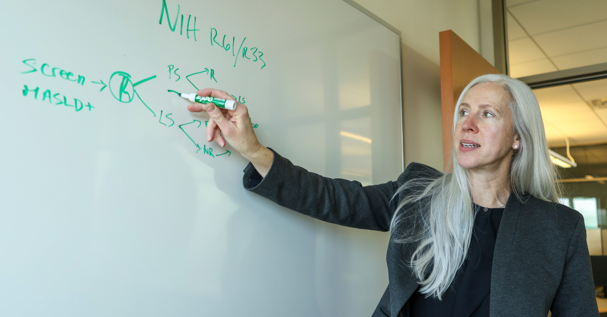 Miriam Vos standing at a whiteboard in the Secchia Center.