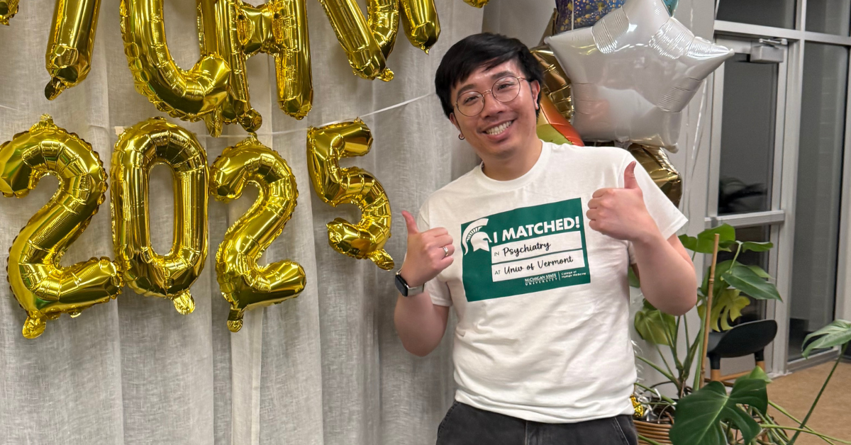 Brandon Leung celebrating match day in front of some balloons.