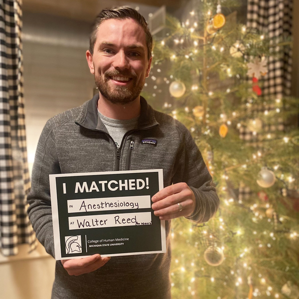 Sam Surgalski, MD candidate, holding Match Day sign