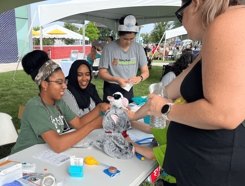 Left to right: Lindsay Dyas (M3), a Hurley Children’s Hospital resident, and Julie Ly (M3).