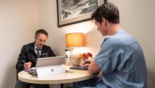 Two people sitting at a table having a discussion.