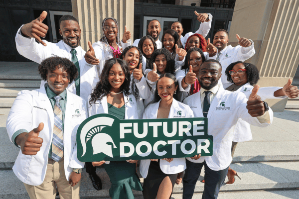 White coat students holding a future doctors sign.